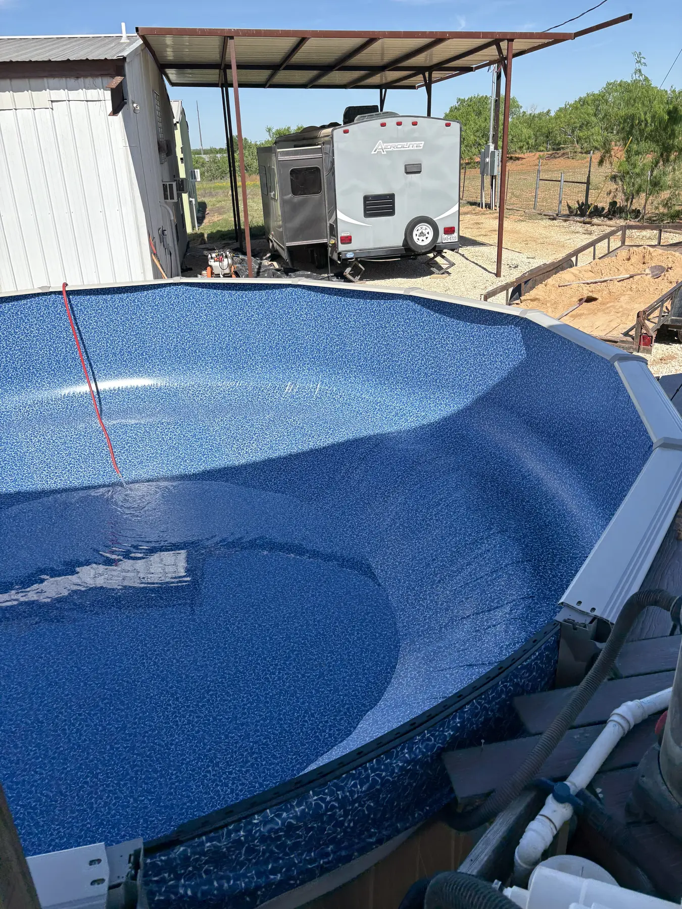 Blue pool liner being positioned inside the pool wall